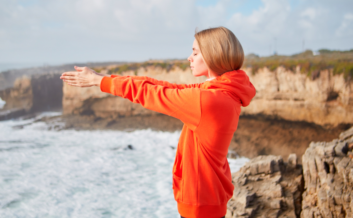 A woman meditating by the sea