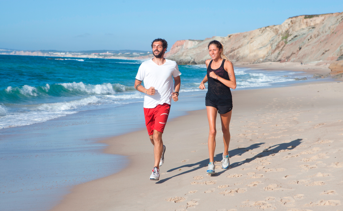 Men and women jogging at the beach